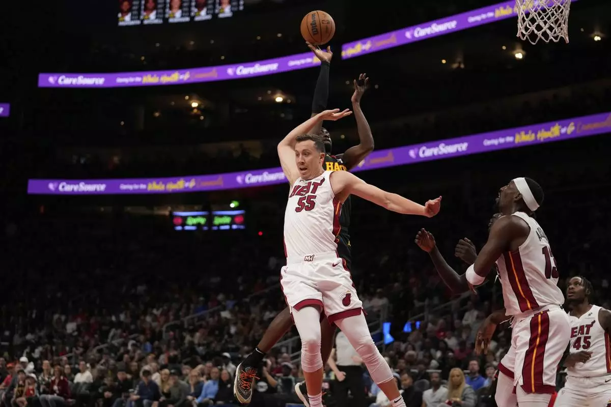 Miami Heat forward Duncan Robinson (55) attempts to block the ball against in the first half of an NBA play-in tournament basketball game against the Friday, April 18, 2025, in Atlanta. (AP Photo/Brynn Anderson)