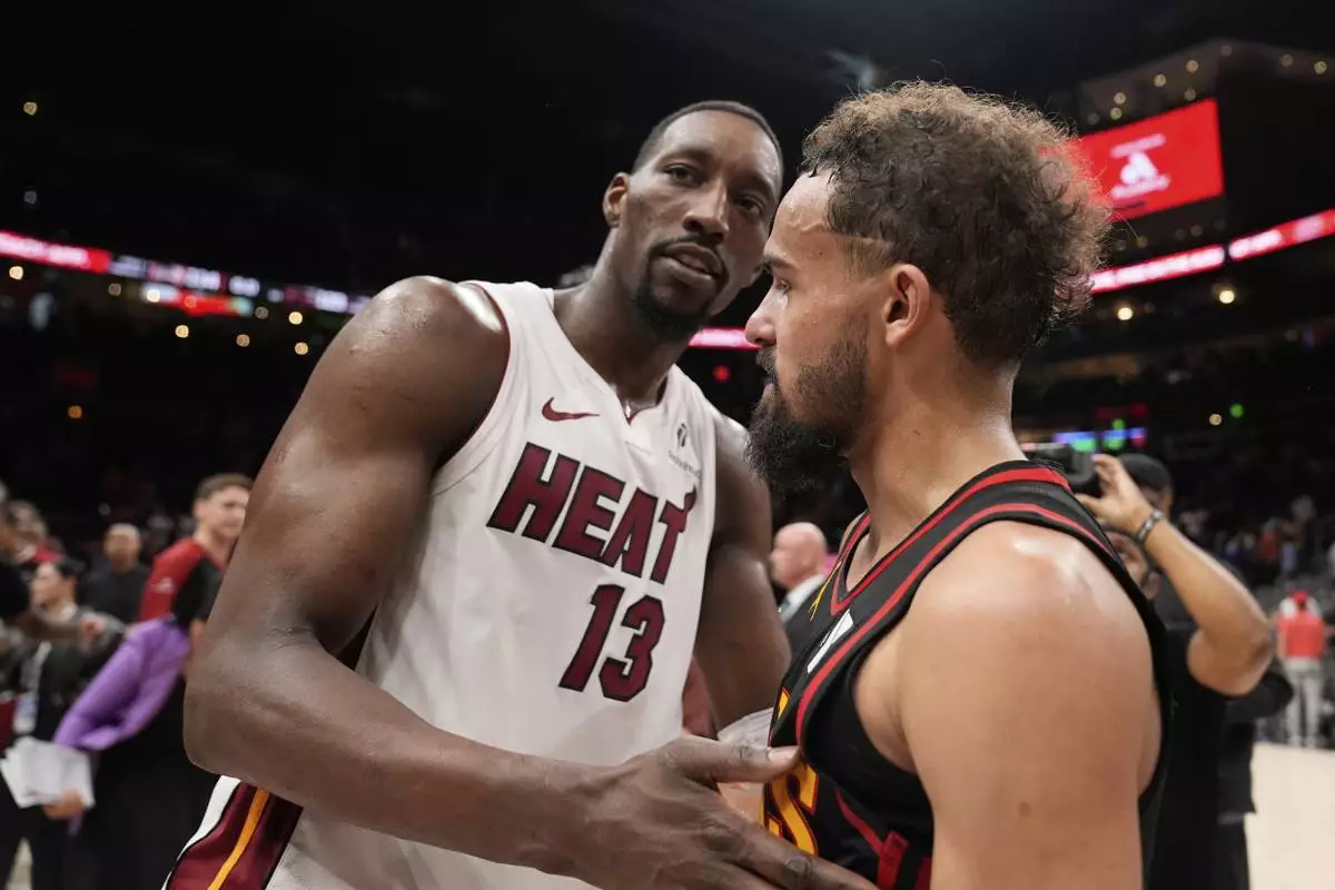 Miami Heat center Bam Adebayo (13) and Atlanta Hawks guard Trae Young (11) meet after an NBA play-in tournament basketball game, Friday, April 18, 2025, in Atlanta. (AP Photo/Brynn Anderson)