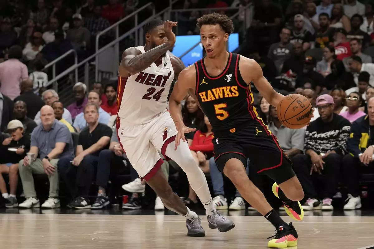 Atlanta Hawks guard Dyson Daniels (5) dribbles against Miami Heat forward Haywood Highsmith (24) in the first half of an NBA play-in tournament basketball game, Friday, April 18, 2025, in Atlanta. (AP Photo/Brynn Anderson)