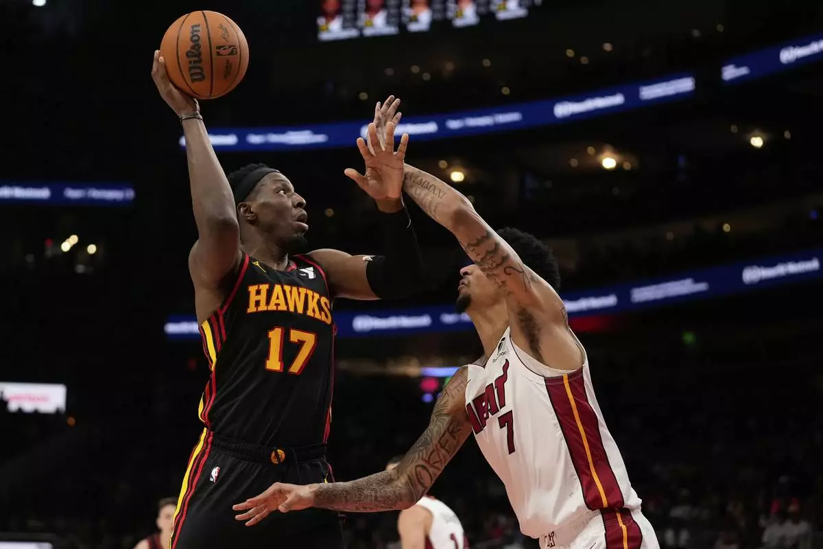 Atlanta Hawks forward Onyeka Okongwu (17) shoots against Miami Heat center Kel'el Ware (7) in the first half of an NBA play-in tournament basketball game, Friday, April 18, 2025, in Atlanta. (AP Photo/Brynn Anderson)