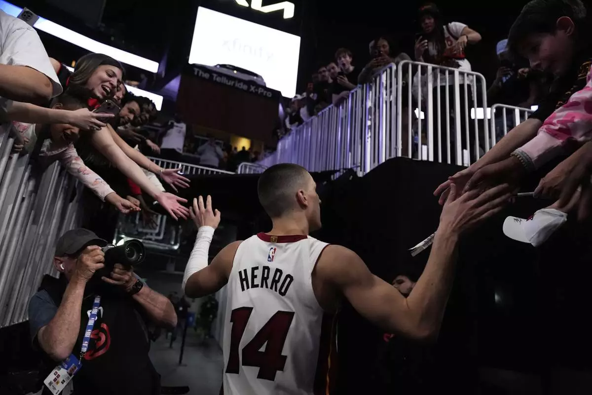 Miami Heat guard Tyler Herro (14) leaves the court after a win against the Atlanta Hawks after an NBA play-in tournament basketball, Friday, April 18, 2025, in Atlanta. (AP Photo/Brynn Anderson)