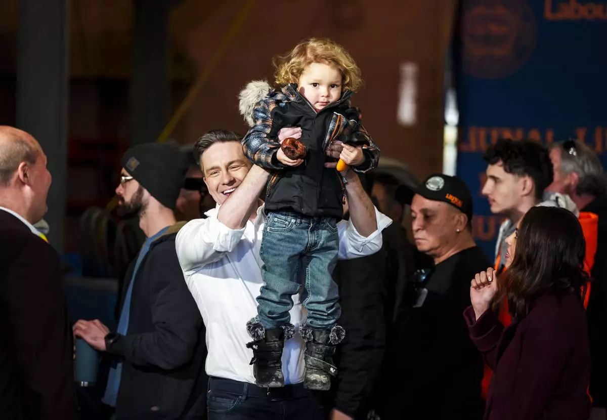 FILE - Conservative Leader Pierre Poilievre lifts his son Cruz up after speaking at a pre-election event in Ottawa, on March 21, 2025. (Justin Tang /The Canadian Press via AP, File)