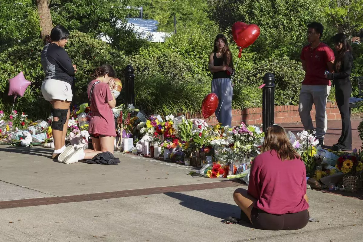 Students gather on a stretch of sidewalk near the center of the Florida State campus in sight of the Student Union building, Tallahassee, Fla., Friday, April 18, 2025. (AP Photo/Gary McCullough)