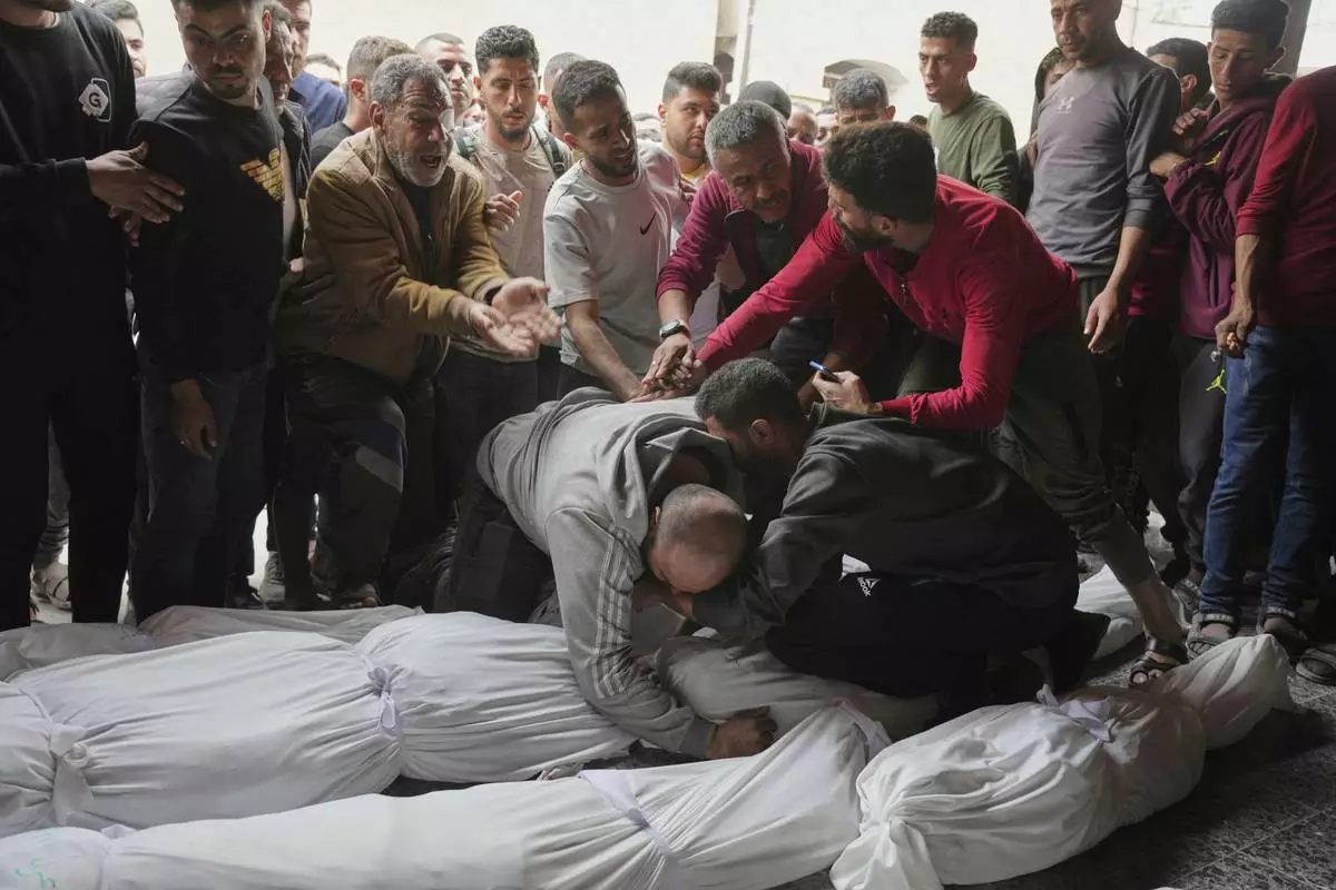 Palestinians mourn over the bodies of their relatives who were killed in an Israeli airstrike in Shijaiyah neighborhood, as they brought to the Baptist Hospital in Gaza City on Wednesday, April 9, 2025. (AP Photo/Jehad Alshrafi)