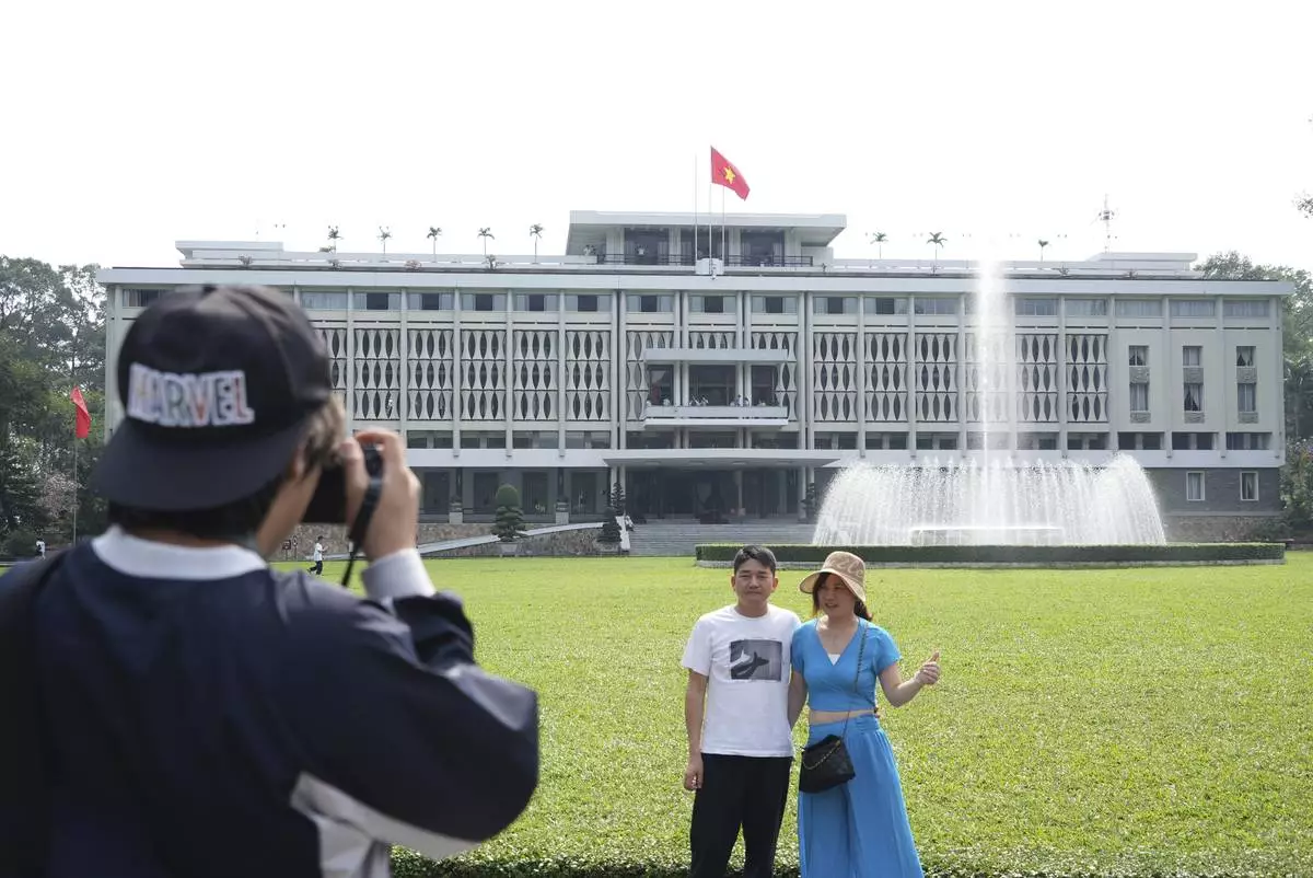Tourists pose for photos in front of Independence Palace in Ho Chi Minh City, Vietnam, Feb. 20, 2025. (AP Photo/Hau Dinh)