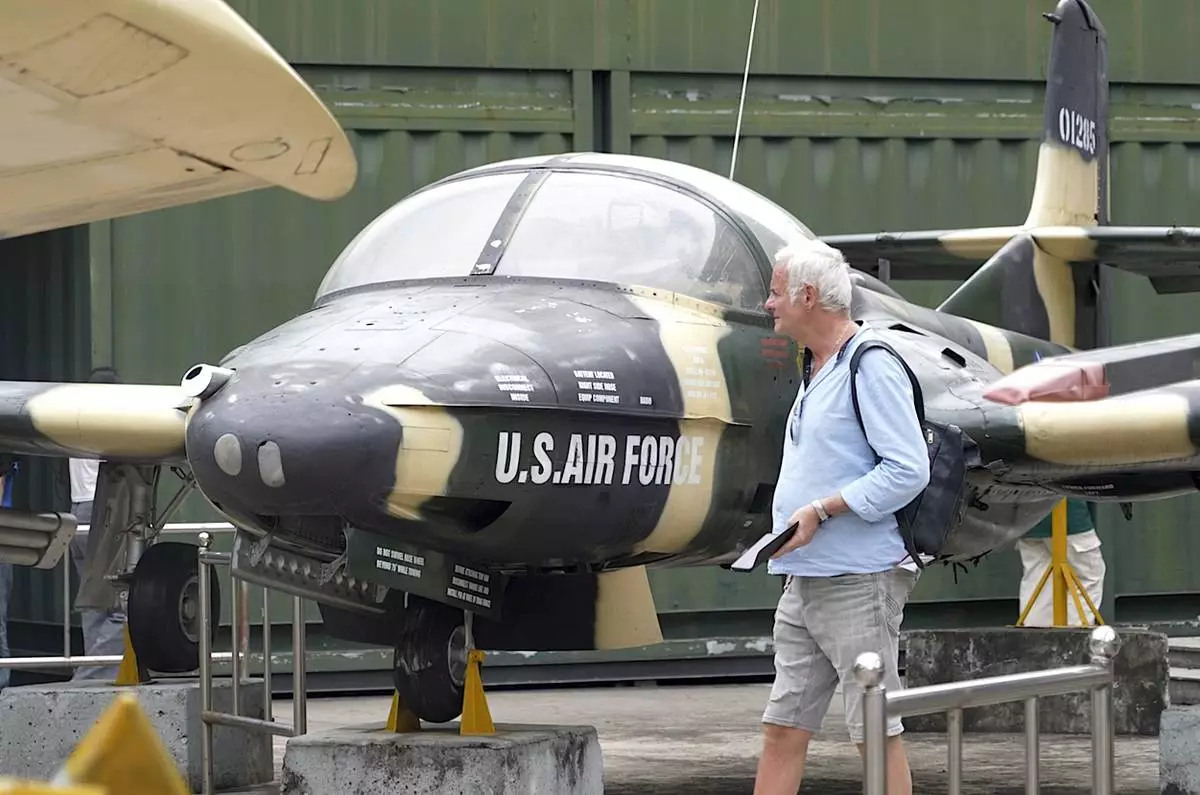 A tourist looks at a U.S Air Force fighter jet used during the Vietnam war on display at the War Remnants Museum in Ho Chi Minh City, Vietnam, Feb. 22, 2025. (AP Photo/Hau Dinh)
