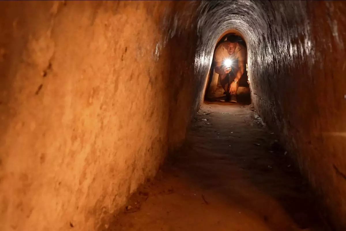 A tourist moves in a narrow tunnel passage in the relic site of Cu Chi tunnels in Ho Chi Minh City, Vietnam, Feb. 23, 2025. (AP Photo/Hau Dinh)