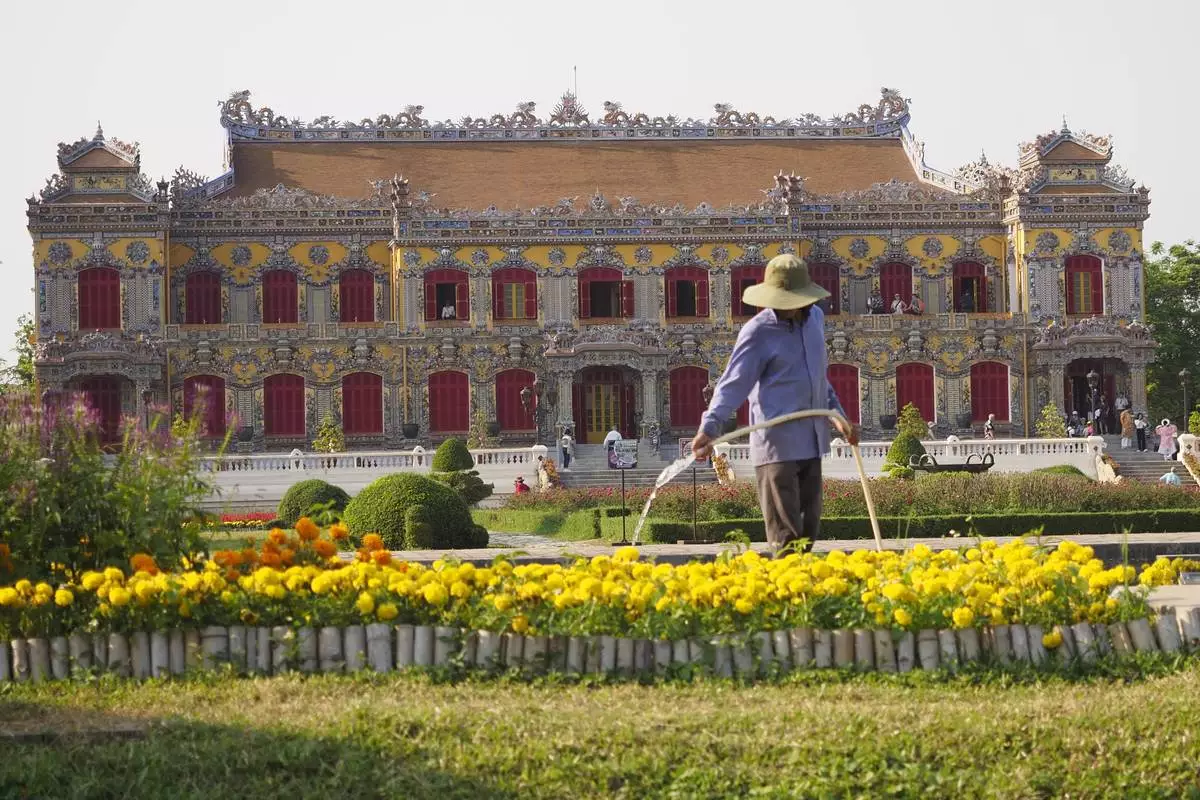A gardener waters flowers outside the newly rebuilt Kien Trung Palace in the Imperial City within the Citadel of Hue, Vietnam, Feb. 21, 2024. (AP Photo/David Rising)