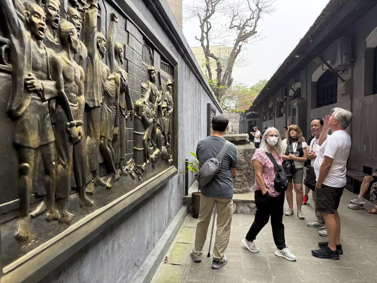 Tourists look at a mural at the Hoa Lo prison museum in Hanoi, Vietnam, March. 26, 2025. (AP Photo/Hau Dinh)