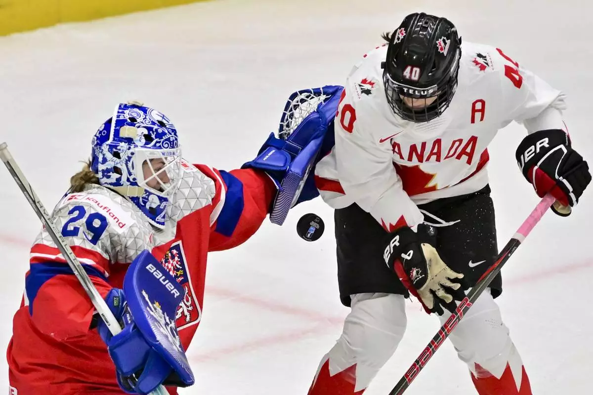 CORRECTS IDENTITY OF PESLAROVA - Czech Republic's Klara Peslarova, left, and Canada's Brianne Jenner in action during the IIHF Women's World Championship, Group A, match between Czech Republic and Canada, in Ceske Budejovice, Czech Republic, Monday, April 14, 2025. (Vaclav Pancer/CTK via AP)