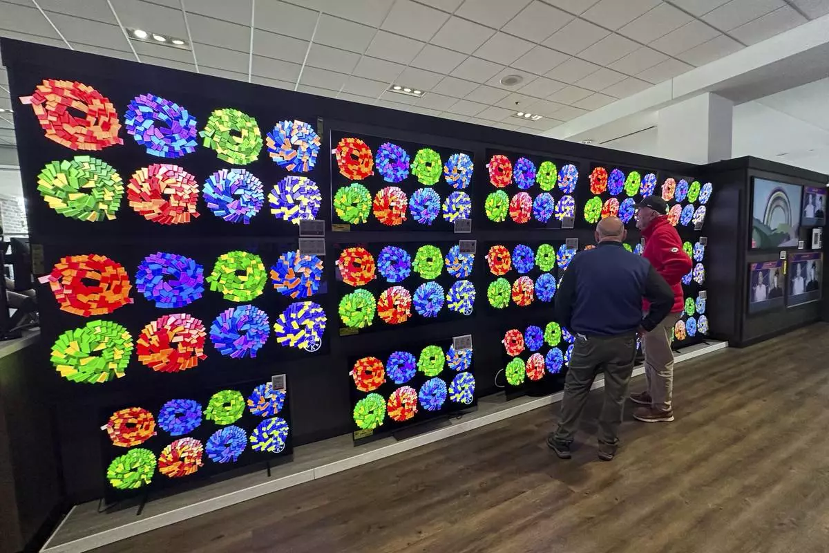 Customers shop televisions at a retail store in Glenview, Ill., Thursday, April 3, 2025. (AP Photo/Nam Y. Huh)