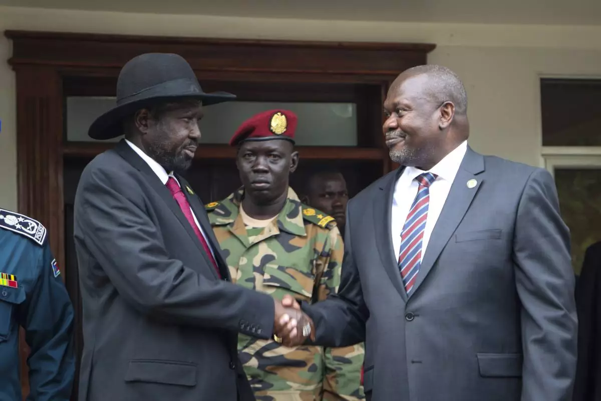 FILE - South Sudan's president Salva Kiir, left, and vice-president Riek Machar, right, shake hands after meetings to discuss outstanding issues to the peace deal on Oct. 20, 2019. (AP Photo/Sam Mednick, File)