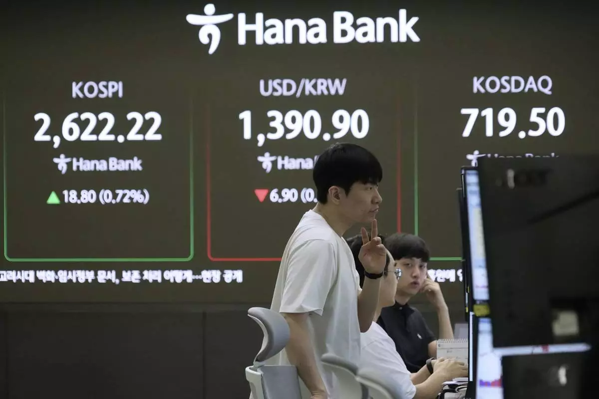A currency trader watches monitors near a screen showing the Korea Composite Stock Price Index (KOSPI), top left, and the foreign exchange rate between U.S. dollar and South Korean won, top center, at the foreign exchange dealing room of the KEB Hana Bank headquarters in Seoul, South Korea, Tuesday, May 20, 2025. (AP Photo/Ahn Young-joon)
