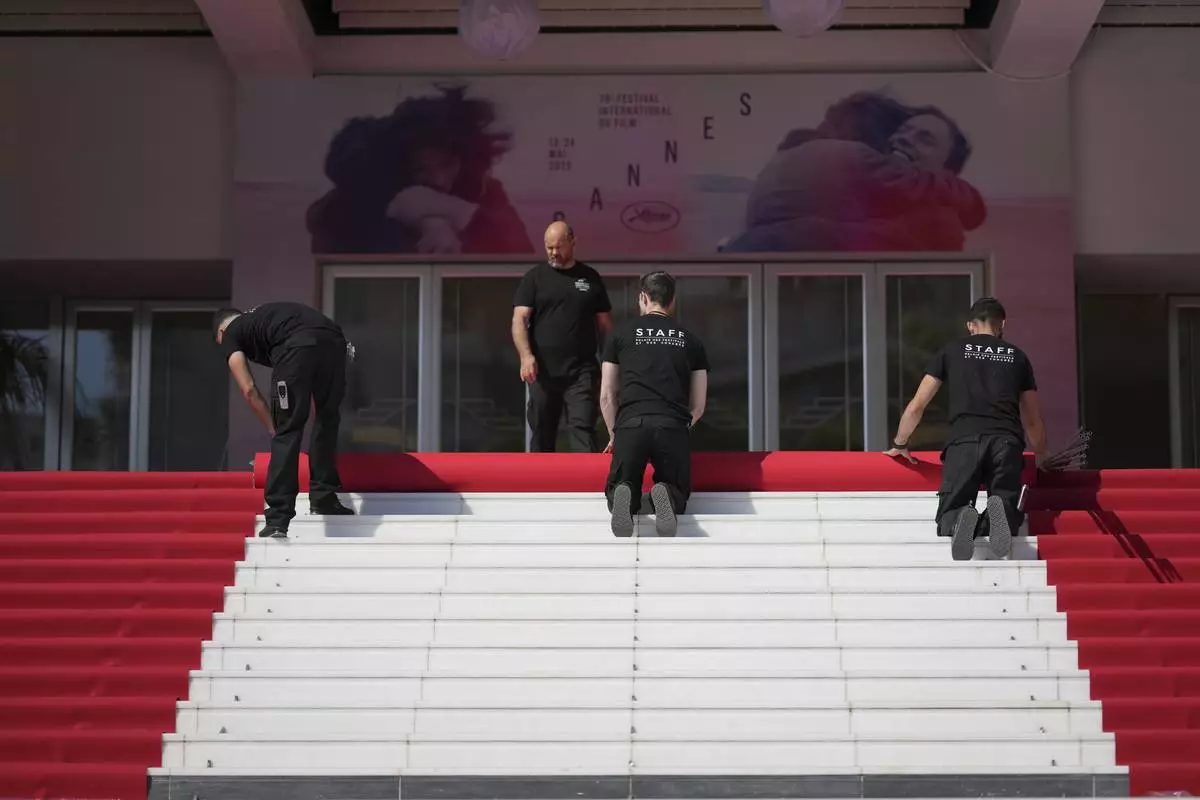 Crew members install the red carpet at the Palais des Festivals ahead of the opening ceremony of the 78th international film festival, Cannes, southern France, Tuesday, May 13, 2025. (Photo by Lewis Joly/Invision/AP)