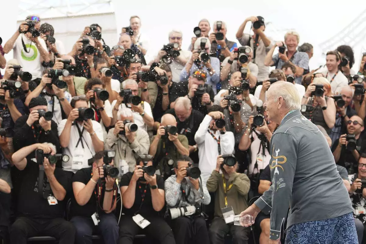 Bill Murray throws water during the photo call for the film 'The Phoenician Scheme' at the 78th international film festival, Cannes, southern France, Monday, May 19, 2025. (Photo by Scott A Garfitt/Invision/AP)