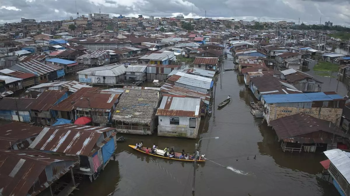 Relatives and friends ride with the coffin of Jorge Luis Mendoza Cuelho, 14, who died electrocuted in the river, during his funeral in Belen, a district nicknamed "Venice of the Jungle" in Iquitos, Peru, Friday, May 23, 2025. (AP Photo/Rodrigo Abd)