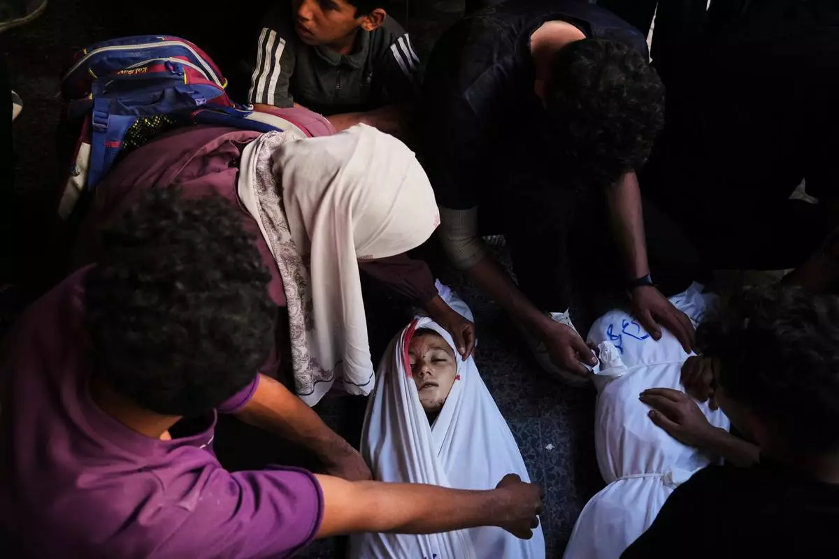 Mourners gather around the body of Palestinian child Ghazwane Hamdan,10, killed in an Israeli army airstrike, and brought to the Baptist Hospital in Gaza City, Monday, May 26, 2025. (AP Photo/Jehad Alshrafi)