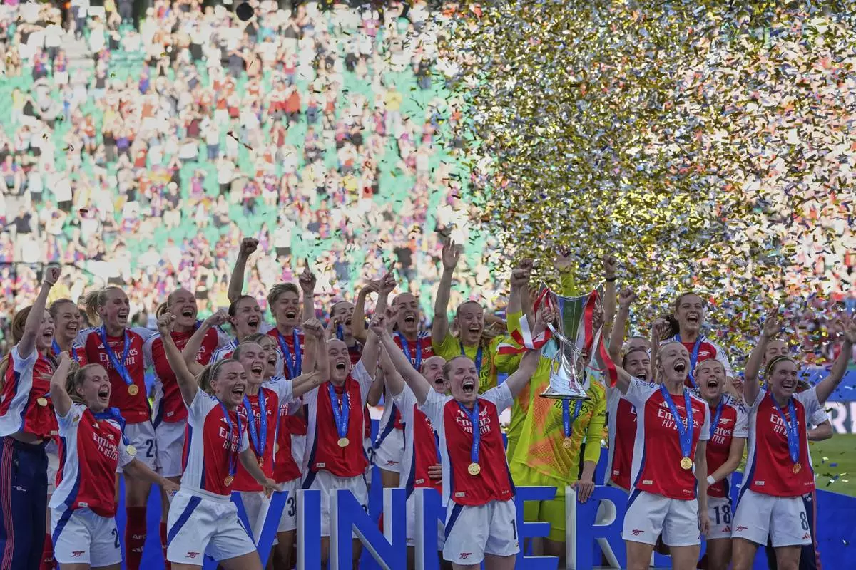 Arsenal players celebrate with their trophy after winning the women's Champions League final soccer match between Arsenal and FC Barcelona at the Jose Alvalade stadium in Lisbon, Saturday, May 24, 2025. (AP Photo/Armando Franca)