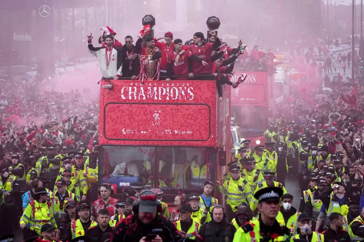 Liverpool players celebrate with the trophy on an open-top bus during the Liverpool FC Premier League victory parade in Liverpool, England, Monday, May 26, 2025. (AP Photo/Jon Super)