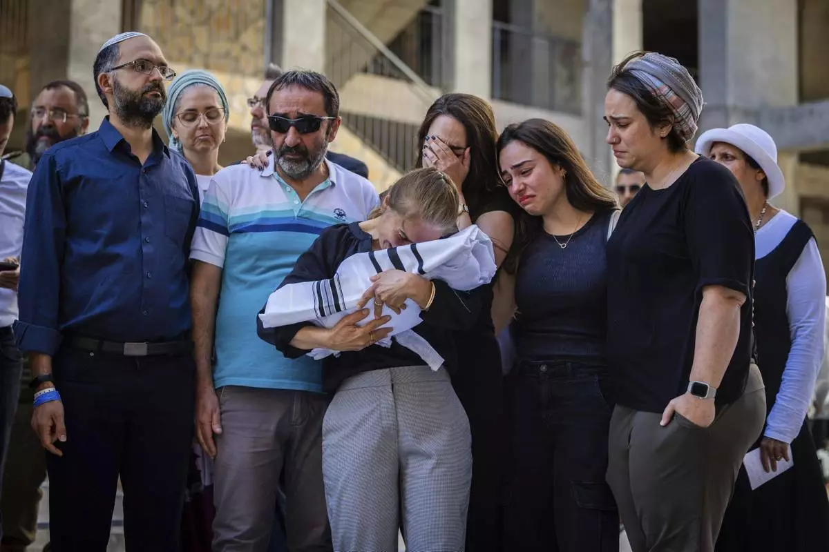 Relatives mourn as they hold the body of two-week-old Israeli infant Ravid Haim, who was delivered after his mother, Tzeela Gez, was shot and killed by a Palestinian gunman in the West Bank while en route to the hospital with her husband to give birth, in Jerusalem, Thursday, May 29, 2025. (AP Photo/Oren Ben Hakoon)