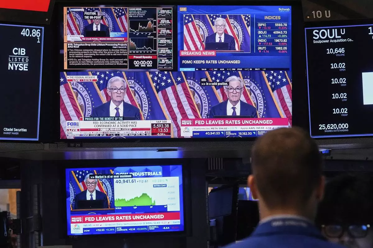 Screens on a trading post on the floor of the New York Stock Exchange show the news conference of Federal Reserve Chair Jerome Powell, Wednesday, May 7, 2025. (AP Photo/Richard Drew)