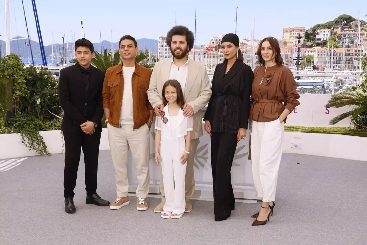 Sinan Mohebi, from back left, Payman Maadi, director Saeed Roustayi, Parinaz Izadyar, Soha Niasti and Arshida Dorostkar, front, pose for photographers at the photo call for the film 'Woman and Child' at the 78th international film festival, Cannes, southern France, Friday, May 23, 2025. (Photo by Joel C Ryan/Invision/AP)