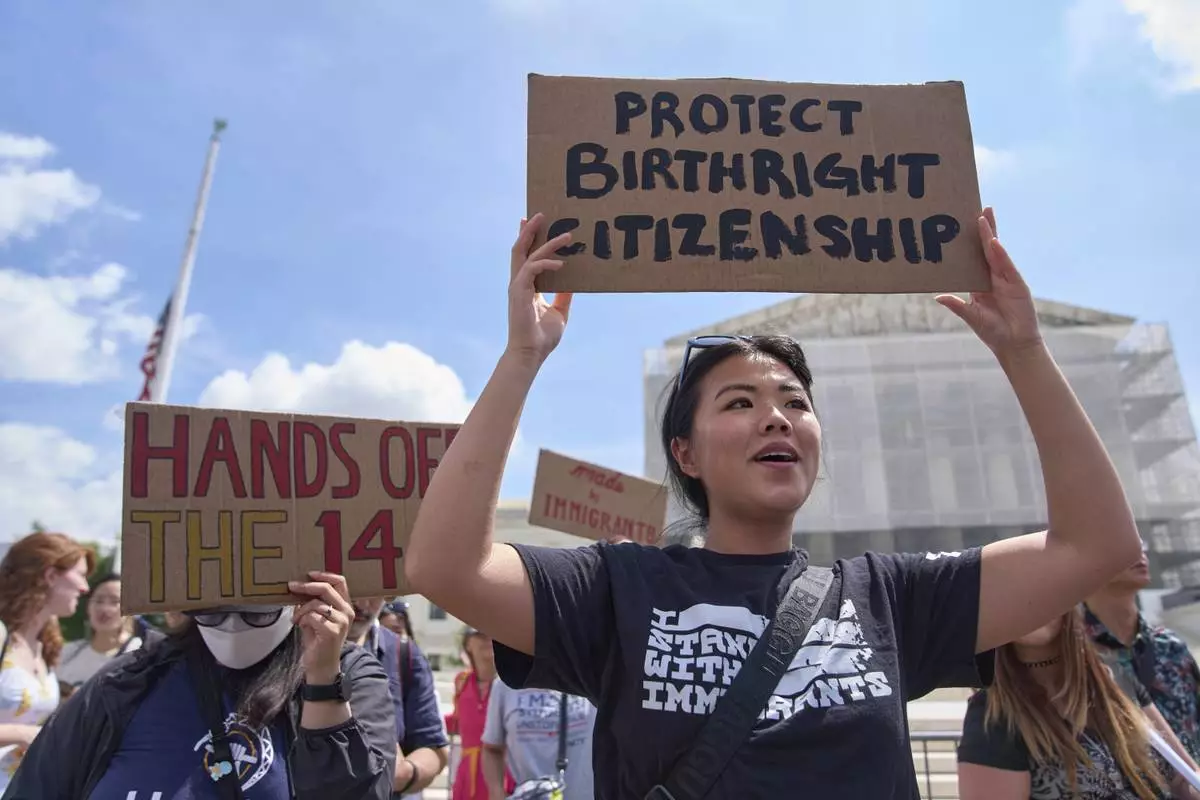 Hannah Liu, 26, of Washington, holds up a sign in support of birthright citizenship, Thursday, May 15, 2025, outside of the Supreme Court in Washington. "This is enshrined in the Constitution. My parents are Chinese immigrants," says Liu. "They came here on temporary visas so I derive my citizenship through birthright." (AP Photo/Jacquelyn Martin)