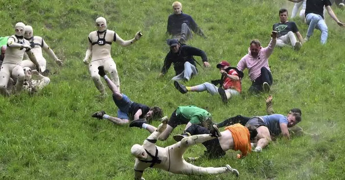 AP PHOTOS: Runners trip, stumble and roll their way to victory in annual downhill cheese chase