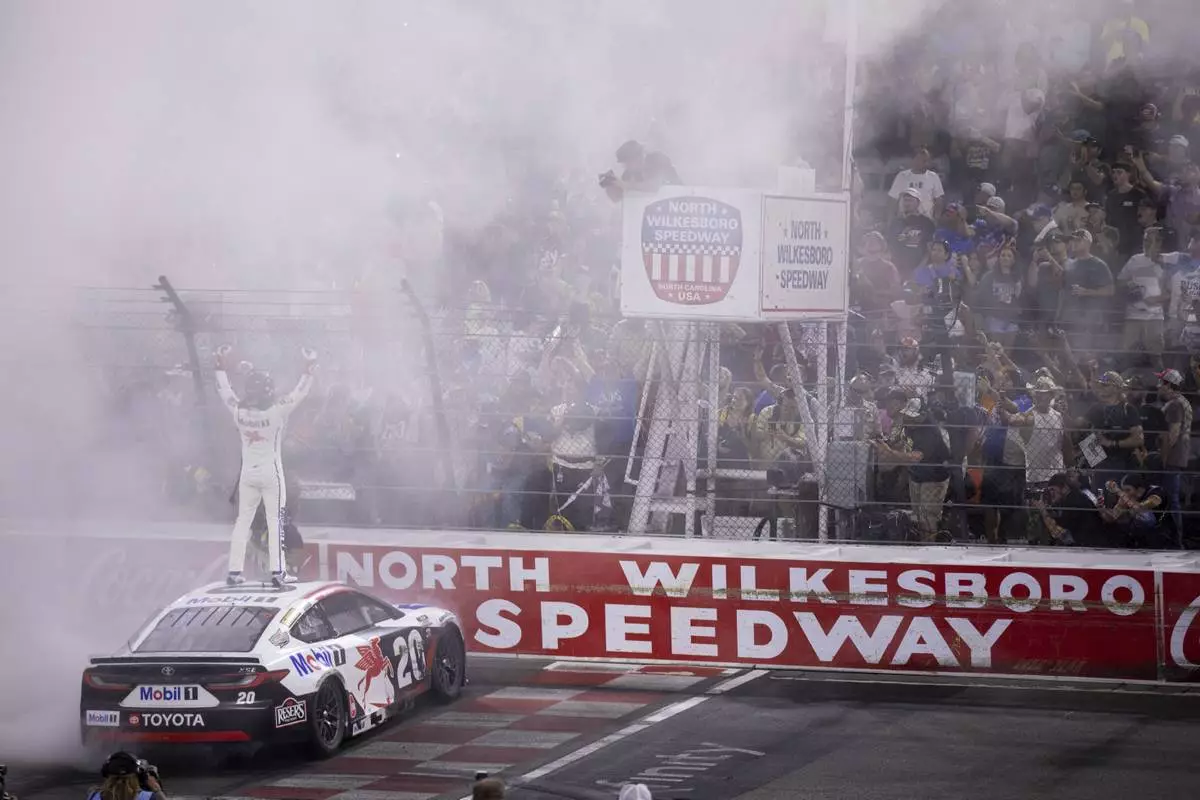 Christopher Bell celebrates winning the NASCAR All-Star auto race Sunday, May 18, 2025, in North Wilkesboro, N.C. (AP Photo/Scott Kinser)