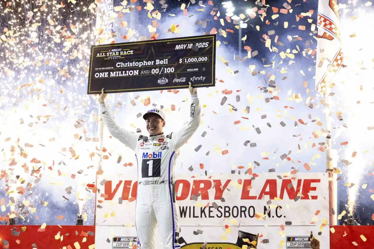 Christopher Bell celebrates after winning the NASCAR All-Star auto race Sunday, May 18, 2025, in North Wilkesboro, N.C. (AP Photo/Scott Kinser)