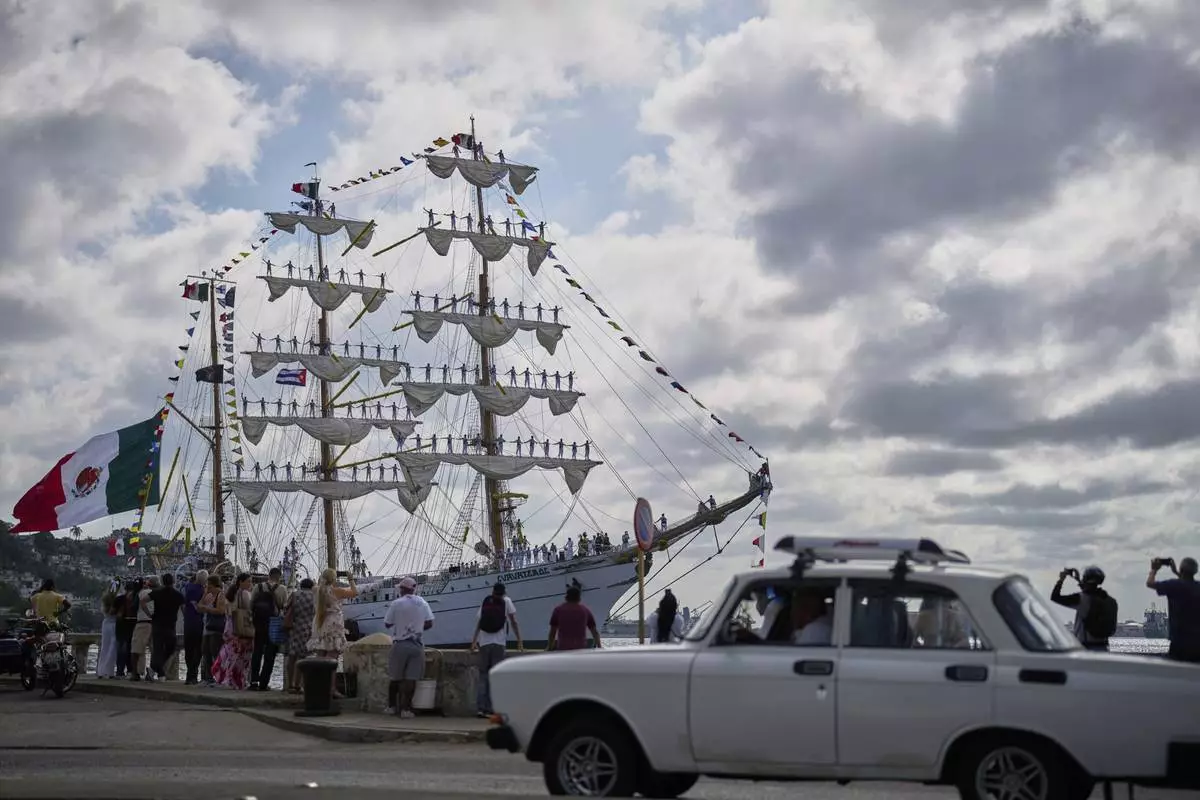 People watch the arrival of Mexican Navy tall ship Cuauhtemoc to Havana Bay, Cuba, Monday, April 28, 2025. (AP Photo/Ramon Espinosa)