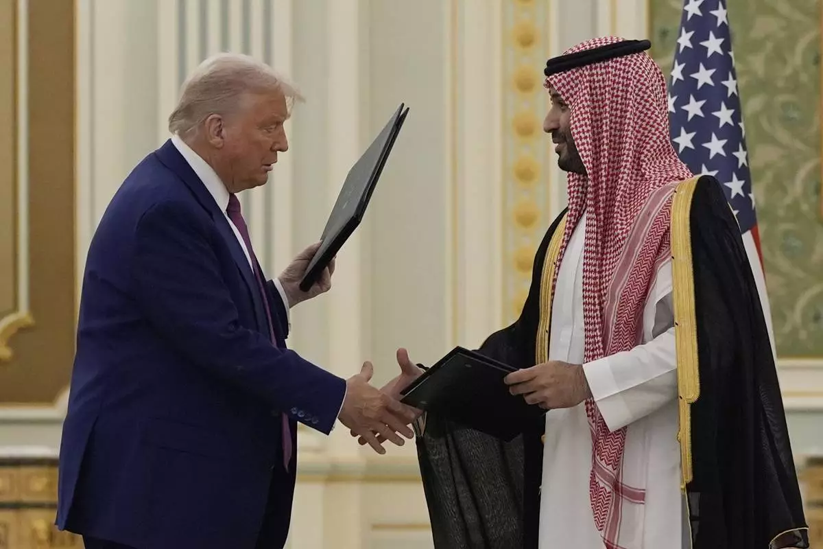 President Donald Trump and Saudi Crown Prince Mohammed bin Salman shake hands after exchanging documents during a signing ceremony at the Royal Palace in Riyadh, Saudi Arabia, Tuesday, May 13, 2025. (AP Photo/Alex Brandon)