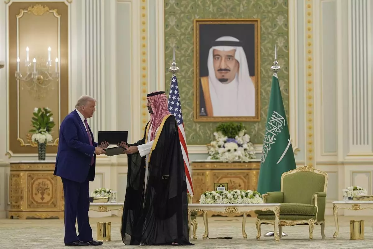 President Donald Trump and Saudi Crown Prince Mohammed bin Salman exchange documents during a signing ceremony at the Royal Palace, Tuesday, May 13, 2025. (AP Photo/Alex Brandon)