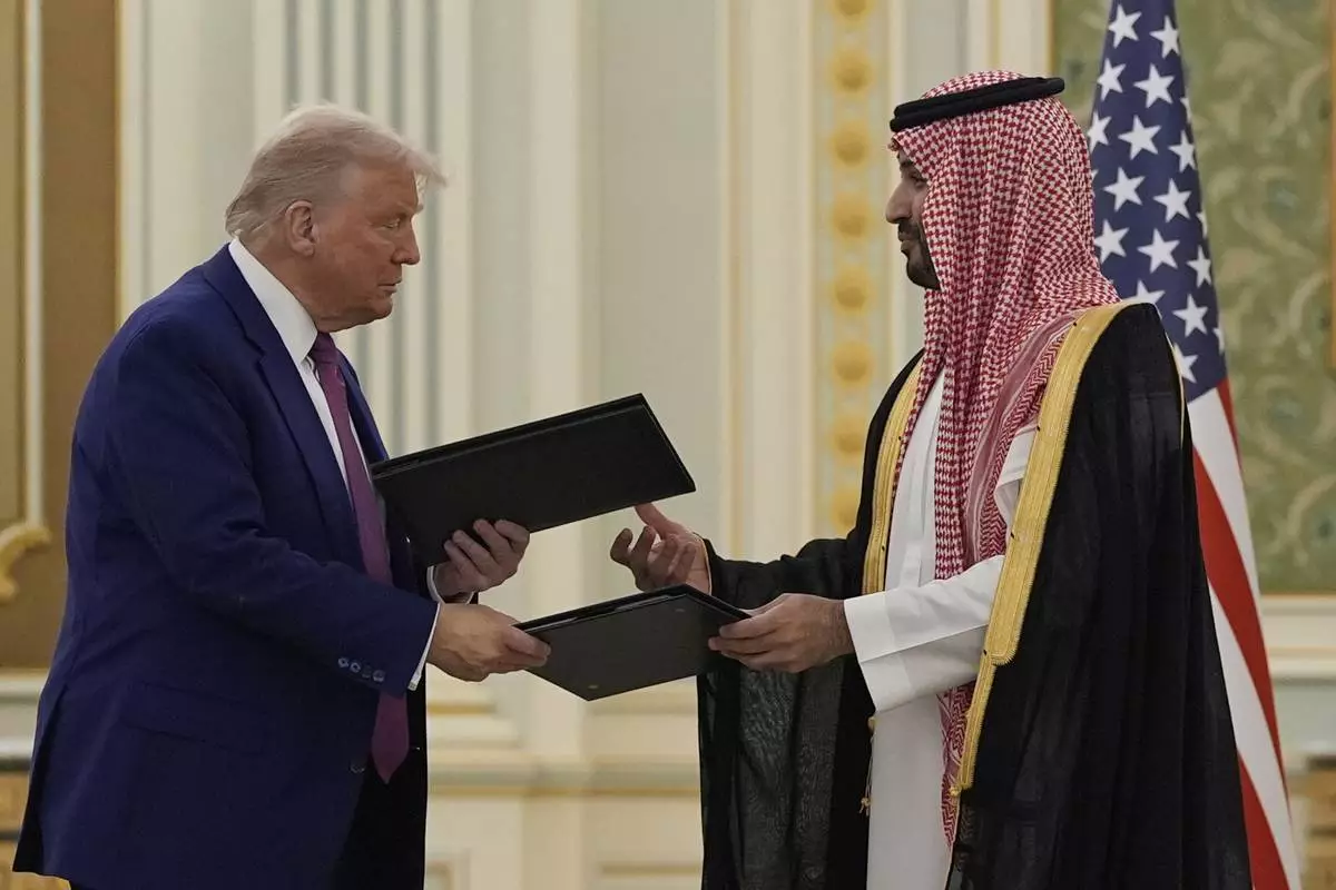 President Donald Trump and Saudi Crown Prince Mohammed bin Salman exchange documents during a signing ceremony at the Royal Palace, Tuesday, May 13, 2025. (AP Photo/Alex Brandon)