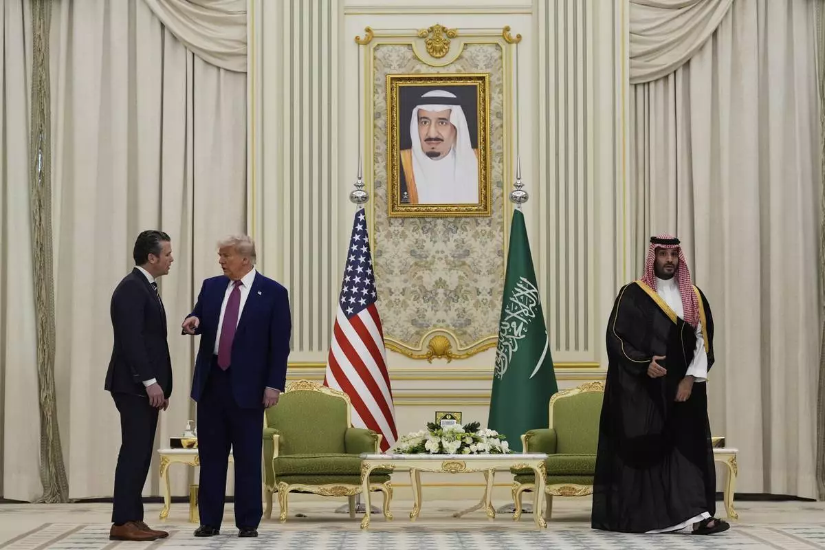 President Donald Trump speaks with Secretary of Defense Pete Hegseth as they attend a signing ceremony with Saudi Crown Prince Mohammed bin Salman at the Royal Palace in Riyadh, Saudi Arabia, Tuesday, May 13, 2025. (AP Photo/Alex Brandon)