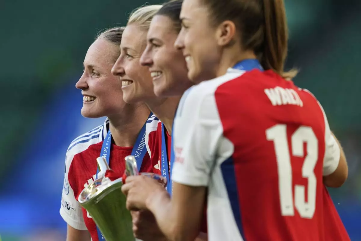From left, Arsenal's Kim Little, Leah Williamson, Steph Catley and Lia Walti pose with the winner trophy after their team won the women's Champions League final soccer match between Arsenal and FC Barcelona at the Jose Alvalade stadium in Lisbon, Saturday, May 24, 2025. (AP Photo/Armando Franca)