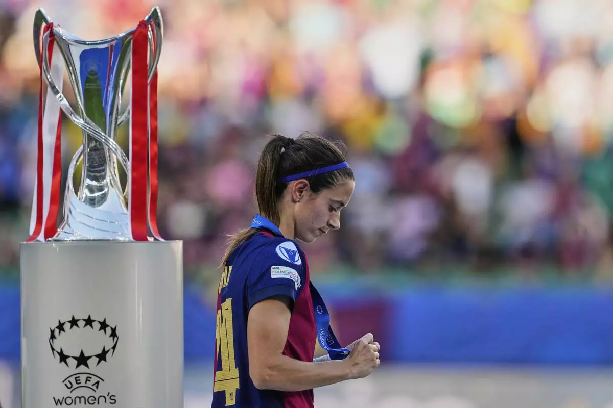 Barcelona's Aitana Bonmati walks past the winner trophy during the podium ceremony after Arsenal won the women's Champions League final soccer match between Arsenal and FC Barcelona at the Jose Alvalade stadium in Lisbon, Saturday, May 24, 2025. (AP Photo/Armando Franca)