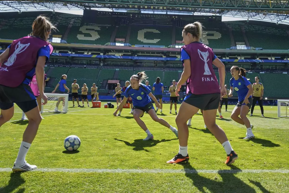 Barcelona's Caroline Graham Hansen, center, plays the ball with team players during a training session, on the eve of the women's Champions League final soccer match between Arsenal and FC Barcelona, at the Jose Alvalade Stadium, in Lisbon, Friday, May 23, 2025. (AP Photo/Armando Franca)