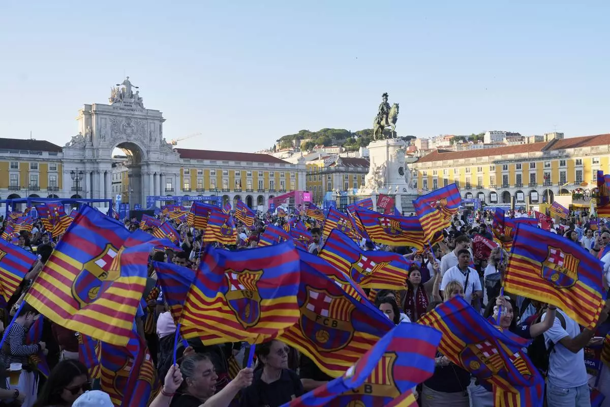 Barcelona fans wave flags at Lisbon's riverside Comercio square, on the eve of the women's Champions League final soccer match between Arsenal and FC Barcelona in Lisbon, Friday, May 23, 2025. (AP Photo/Ana Brigida)