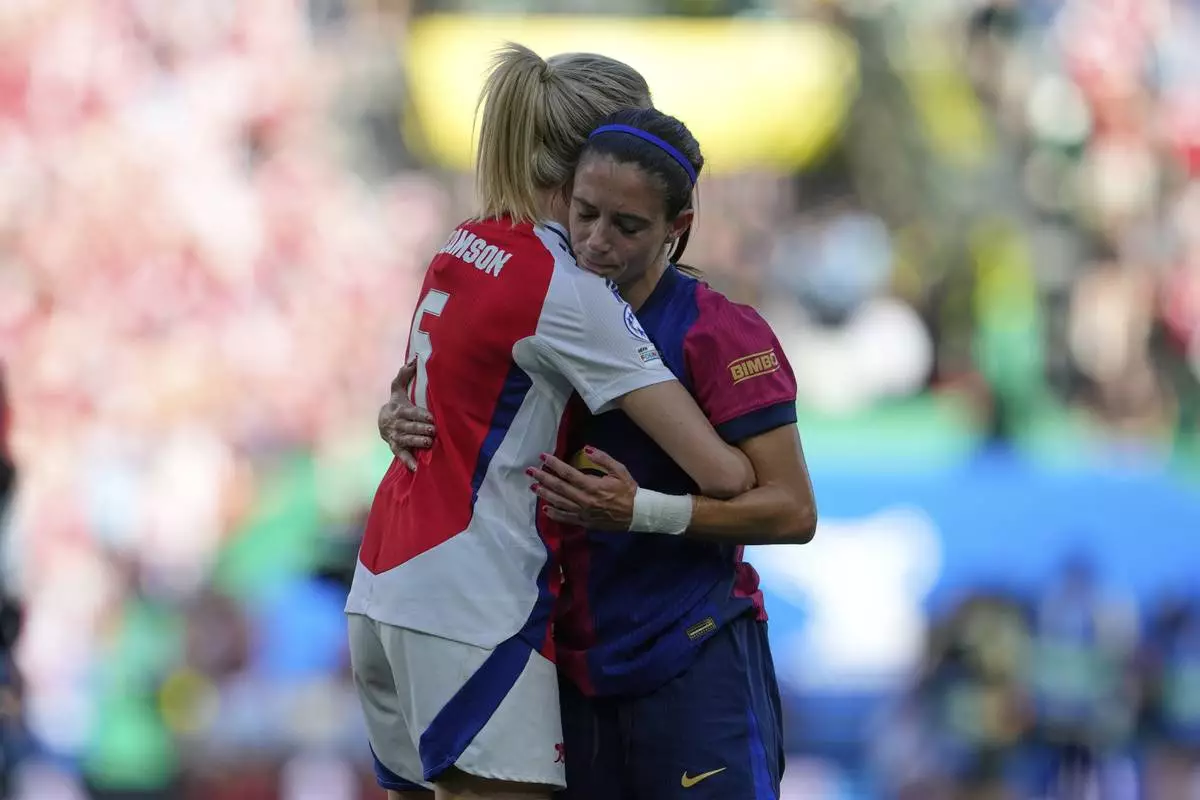 Barcelona's Aitana Bonmati, right, greets Arsenal's Leah Williamson at the end of the women's Champions League final soccer match between Arsenal and FC Barcelona at the Jose Alvalade stadium in Lisbon, Saturday, May 24, 2025. (AP Photo/Armando Franca)