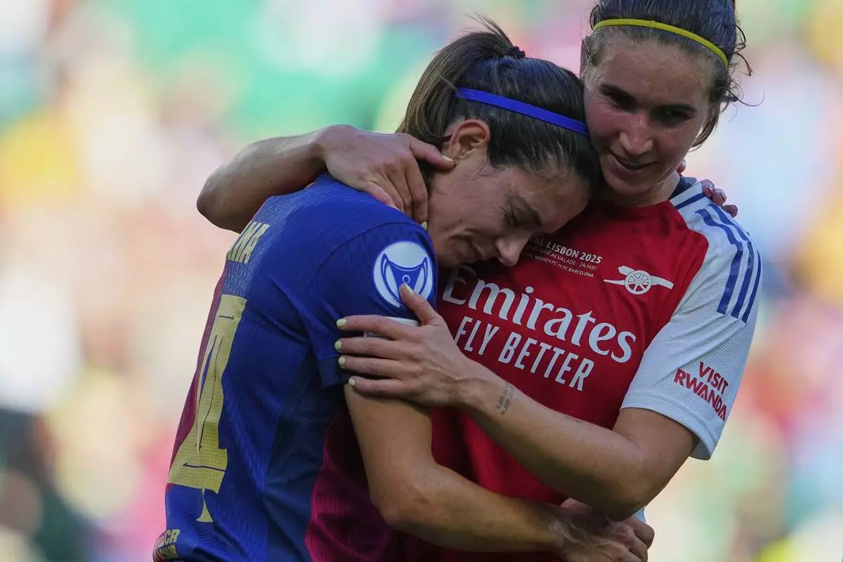 Barcelona's Aitana Bonmati, left, is comforted by Arsenal's Mariona Caldentey at the end of the women's Champions League final soccer match between Arsenal and FC Barcelona at the Jose Alvalade stadium in Lisbon, Saturday, May 24, 2025. (AP Photo/Armando Franca)
