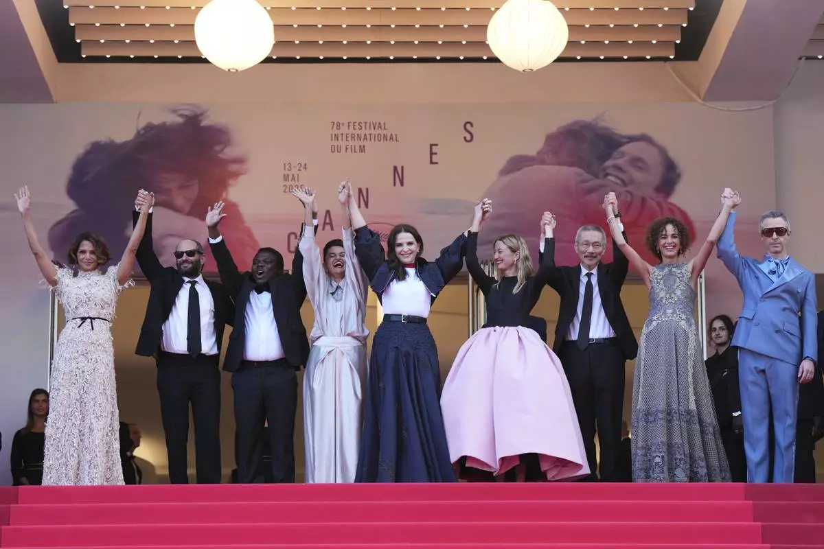 Jury president Juliette Binoche, center, poses with jury members Halle Berry, from left, Carlos Reygadas, Dieudo Hamadi, Payal Kapadia, Alba Rohrwacher, Hong Sang-soo, Leila Slimani and Jeremy Strong during the awards ceremony red carpet at the 78th international film festival, Cannes, southern France, Saturday, May 24, 2025. (Photo by Lewis Joly/Invision/AP)