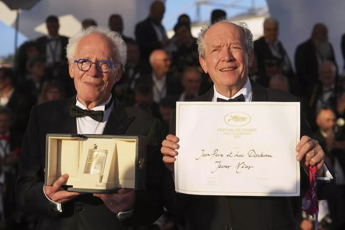 Directors Jean-Pierre Dardenne, left, and Luc Dardenne, winners of award for best screenplay for 'Jeunes Meres,' pose for photographers at the awards ceremony photo call at the 78th international film festival, Cannes, southern France, Saturday, May 24, 2025. (AP Photo/Natacha Pisarenko)