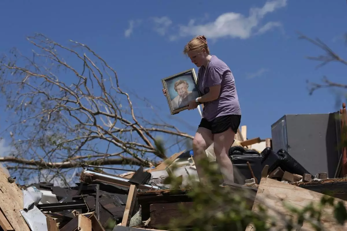 Hailee Allen holds a family picture saved from Lynn and Don White's home after a tornado, Saturday, May 17, 2025, in London, Ky. (AP Photo/Carolyn Kaster)