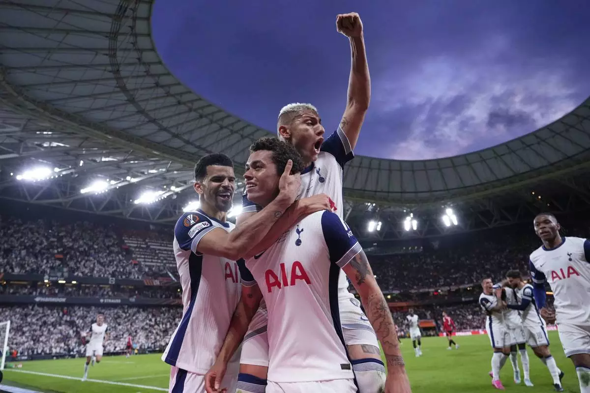 Tottenham's Brennan Johnson, centre, celebrates after scoring his side's opening goal during the Europa League final soccer match between Tottenham Hotspur and Manchester United at the San Mames Stadium in Bilbao, Spain, Wednesday, May 21, 2025. (AP Photo/Jose Breton)