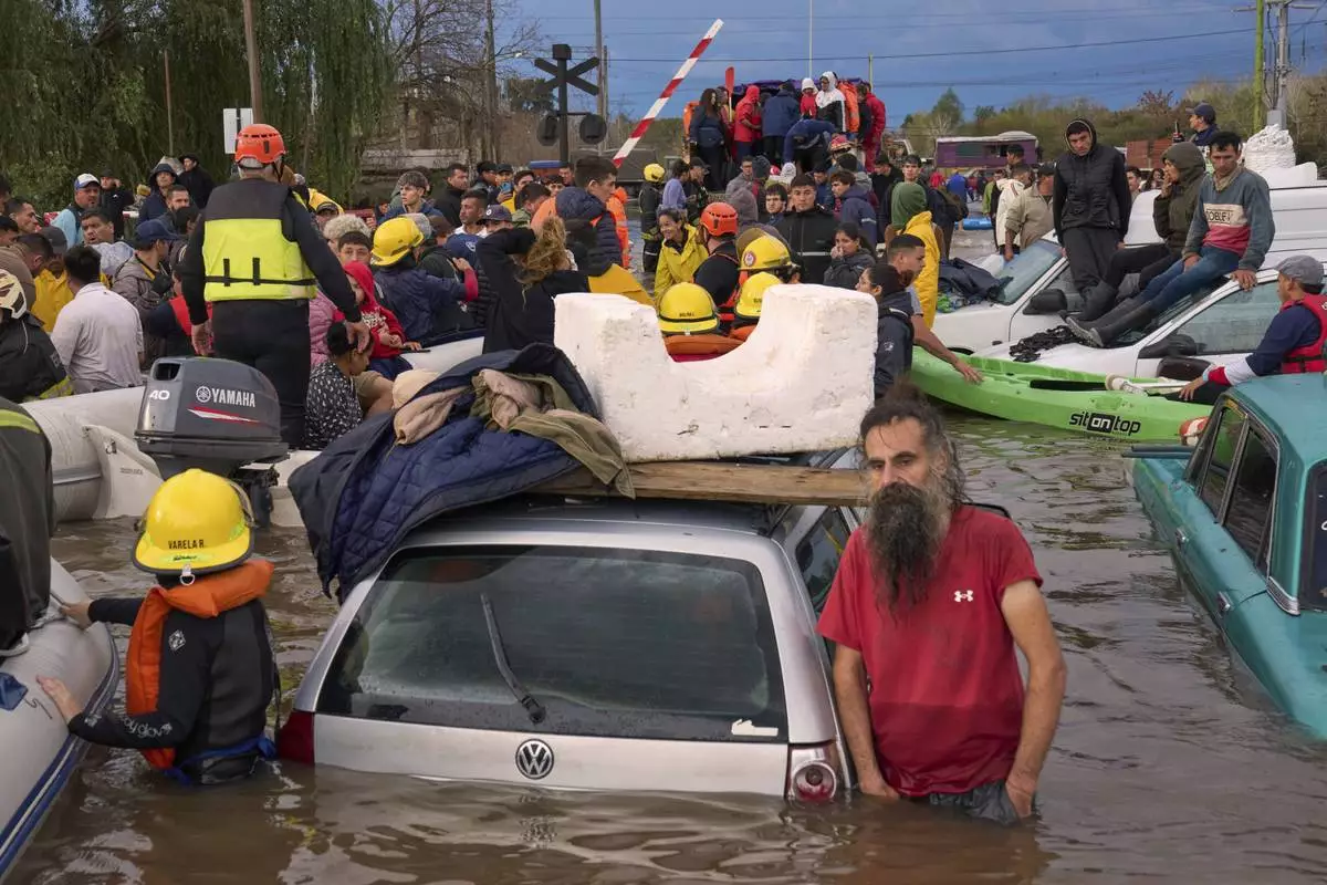 Rescue workers evacuate residents following heavy rains in Campana, Argentina, Saturday, May 17, 2025. (AP Photo/Rodrigo Abd)
