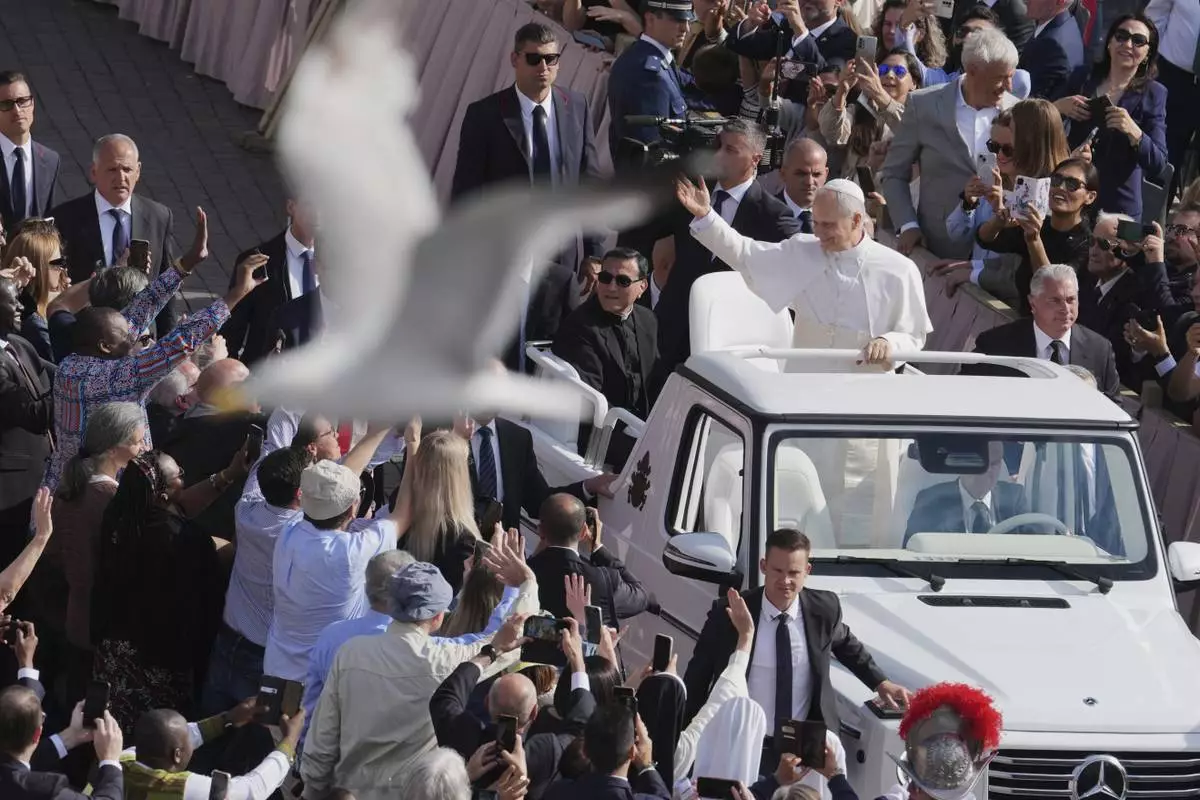 A bird flies by as Pope Leo XIV on his popemobile tours St. Peter's Square at the Vatican prior to the inaugural Mass of his pontificate, Sunday, May 18, 2025. (AP Photo/Jacquelyn Martin, Pool)
