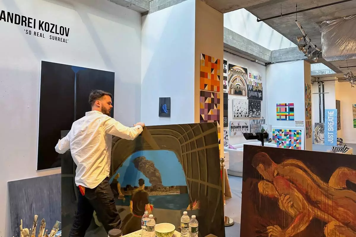 Andrei Kozlov, who was taken hostage by Hamas during the Oct. 7, 2023, attack on Israel, carries a painting through his studio Monday, May 19, 2025, in New York. (AP Photo/Matt Sedensky)