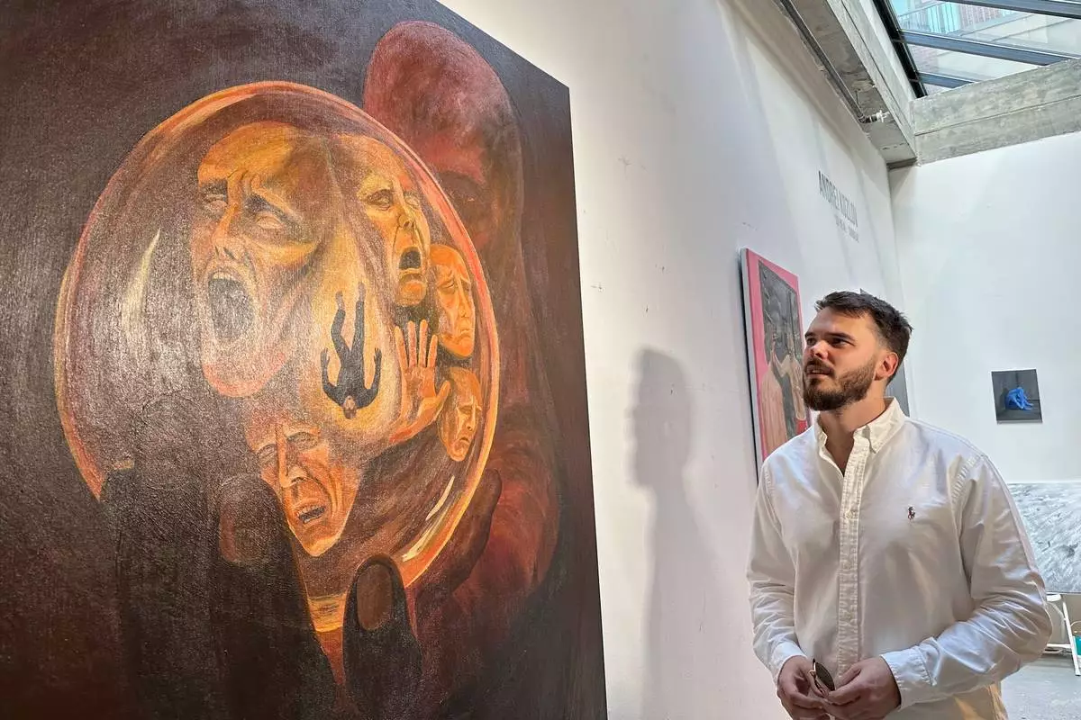 Andrei Kozlov, who was taken hostage by Hamas during the Oct. 7, 2023, attack on Israel, looks at one of his paintings Monday, May 19, 2025, at his studio in New York. (AP Photo/Matt Sedensky)