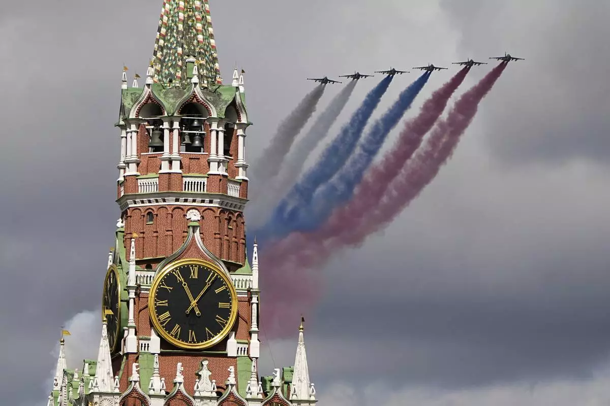 Russian Air Force Su-25 jets fly over Red Square leaving trails of smoke in the colors of the Russian national flag during the Victory Day military parade rehearsal with the Spasskaya Tower in Moscow, Russia, on Monday, May 5, 2025, marking the 80th anniversary of the end of World War II. (AP Photo/Alexander Zemlianichenko)